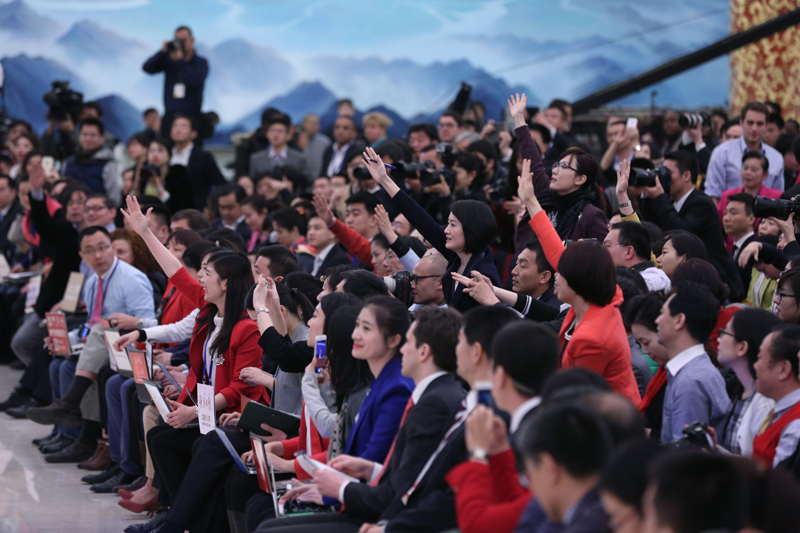 3月15日，國務院總理李克強在北京人民大會堂與中外記者見面，并回答記者提問。這是記者舉手爭取提問機會。 新華社記者 才揚 攝