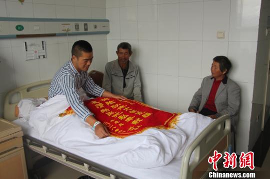 被救的李忠起、張總鳳夫婦看望受傷后的李運(yùn)飛。　汪渝 攝
