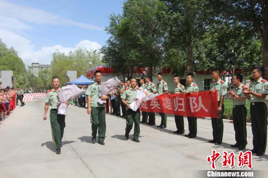 部隊(duì)官兵們迎接出院歸來(lái)的李運(yùn)飛(中)和其他消防戰(zhàn)士。　汪渝 攝