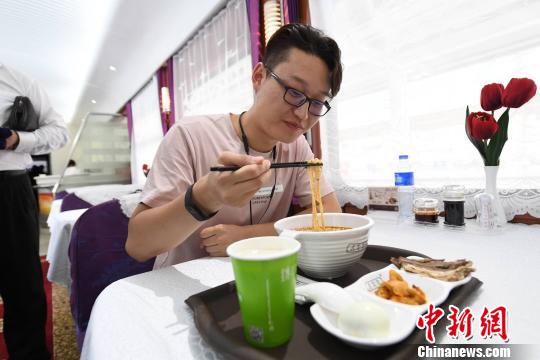 圖為旅客在列車上享用正宗牛肉面?！钇G敏 攝