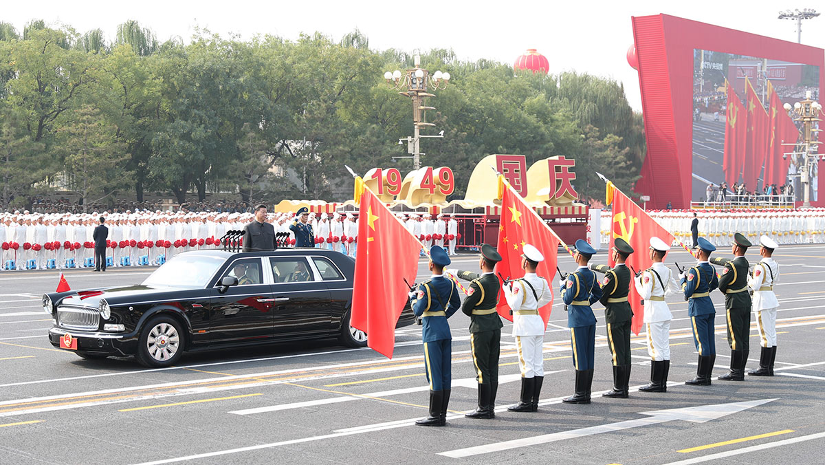 習(xí)近平驅(qū)車行進至黨旗、國旗、軍旗前，向旗幟行注目禮