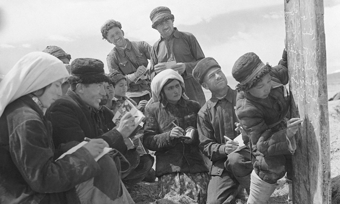 1960年6月，新疆慕士塔格峰下，大人們在小學生幫助下學習文化。新華社記者武純展攝